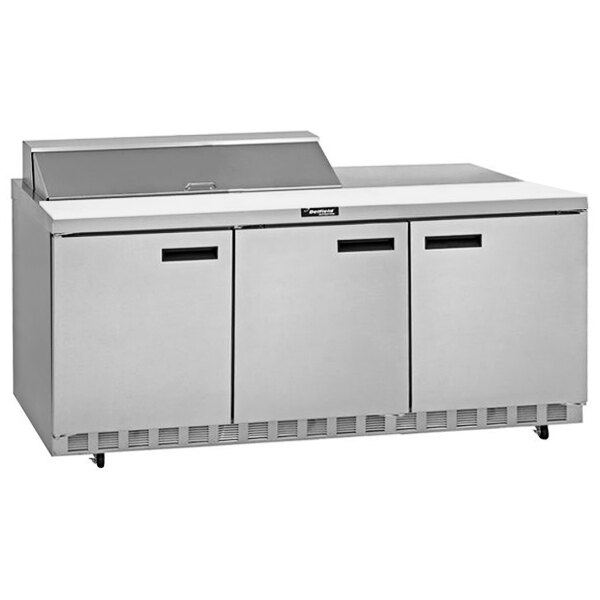 A stainless steel Delfield refrigerator with three doors and a top for preparing sandwiches on a counter.