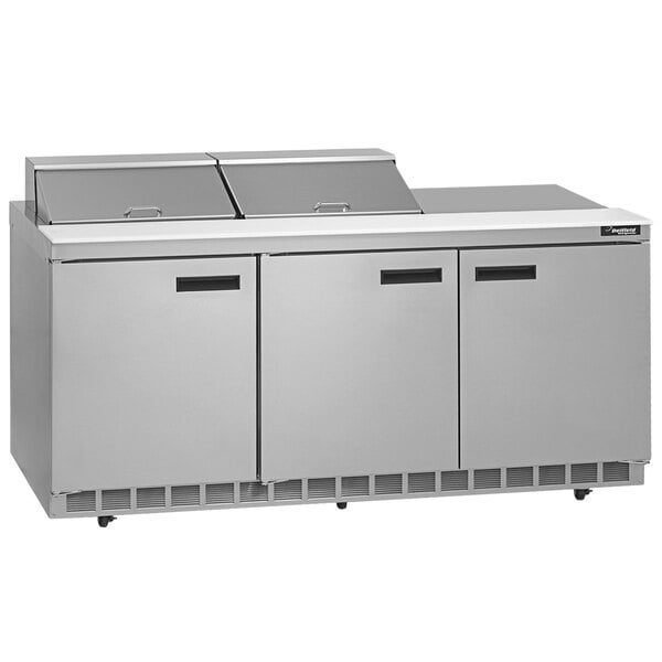 A stainless steel Delfield commercial sandwich prep table with three doors.