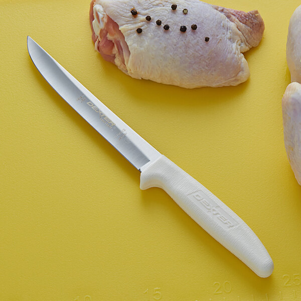 A Dexter-Russell Sani-Safe boning knife next to a piece of meat.