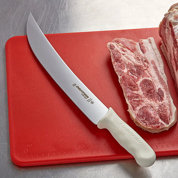 A Dexter-Russell Sani-Safe Cimeter steak knife on a cutting board with a piece of meat.