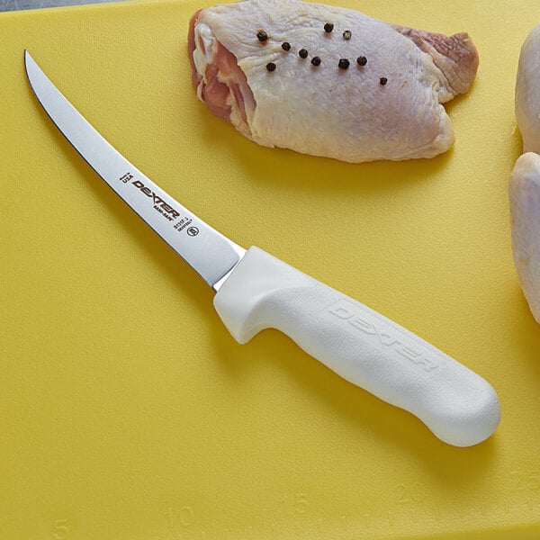 A Dexter-Russell Sani-Safe curved boning knife on a cutting board with a piece of meat.