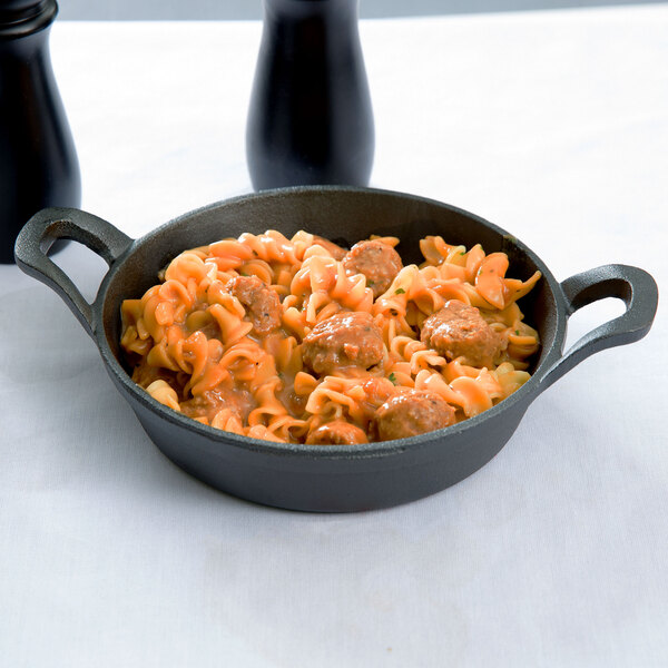 An American Metalcraft pre-seasoned mini cast iron round casserole dish filled with pasta and meatballs.