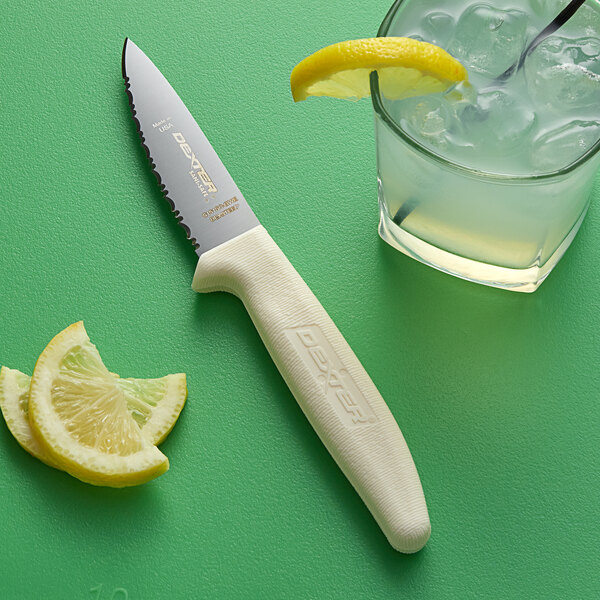 A Dexter-Russell Sani-Safe Utility Knife next to a glass of ice and lemon slices.