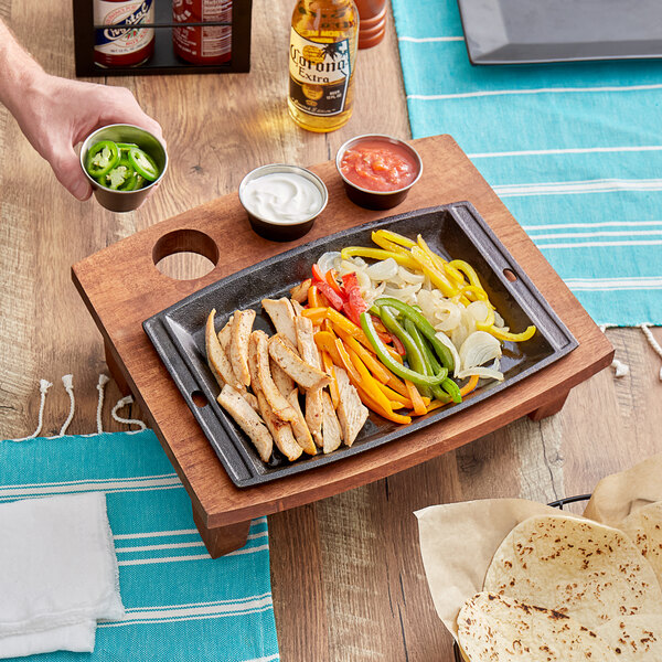 A Valor Rubberwood display stand with food and sauce cups on a wood surface.