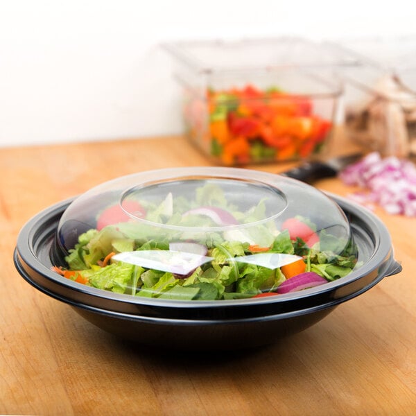 A clear domed lid on a bowl of salad.