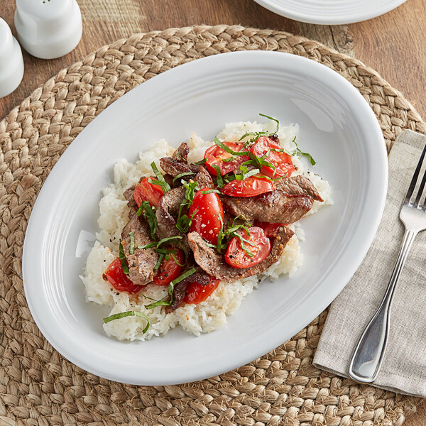 An Acopa Capri coconut white stoneware platter with rice and meat on it.