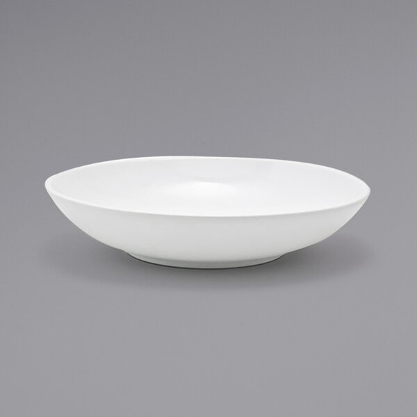 A Front of the House white oval porcelain bowl on a gray surface.