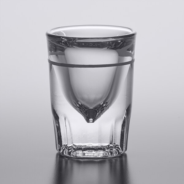A close-up of an Anchor Hocking fluted shot glass with a clear liquid inside.