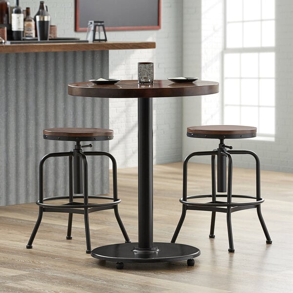 A Lancaster Table & Seating cast iron counter height table base with FLAT Tech levelers on a table in a restaurant.