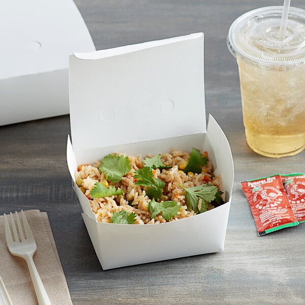 A white Fold-Pak Bio-Pak take-out box of rice and vegetables with a drink and clear plastic cup.