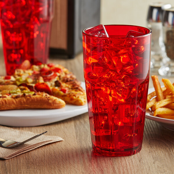 A red GET Bahama plastic tumbler with ice and a plate of pizza.