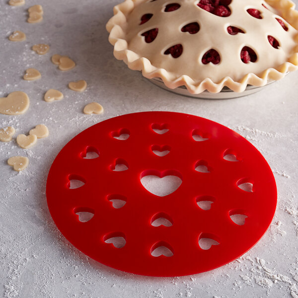 A red Fox Run heart shaped pie crust cutter with heart cutouts.