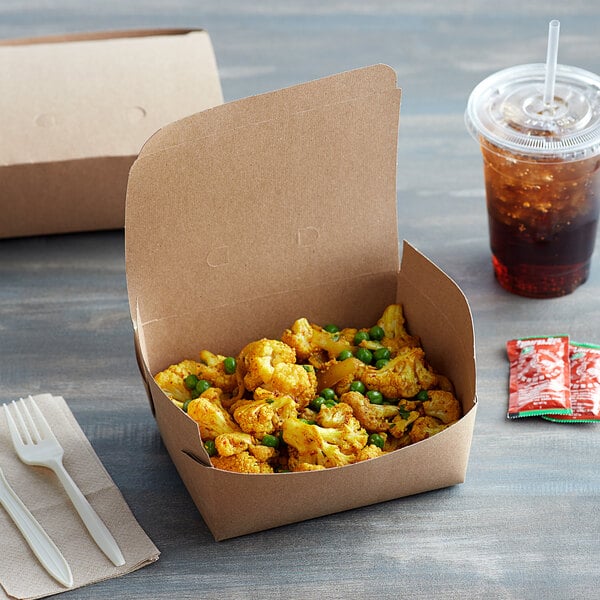 A Fold-Pak Bio-Plus Dine take-out box of food on a table with a drink and napkins.