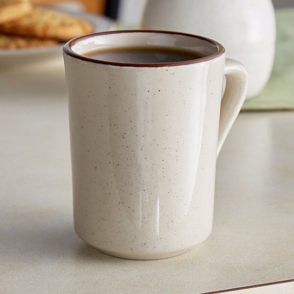 An Acopa brown speckle stoneware coffee cup on a table.
