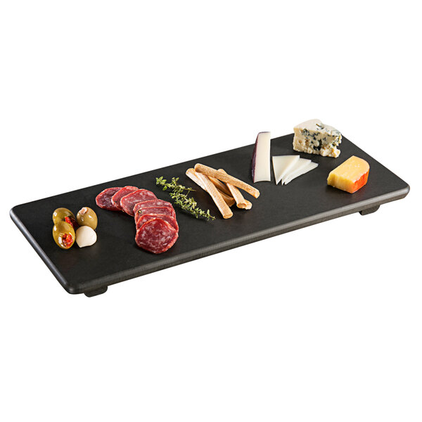 A Tomlinson black Richlite wood fiber serving board with different types of meats and cheese on it.