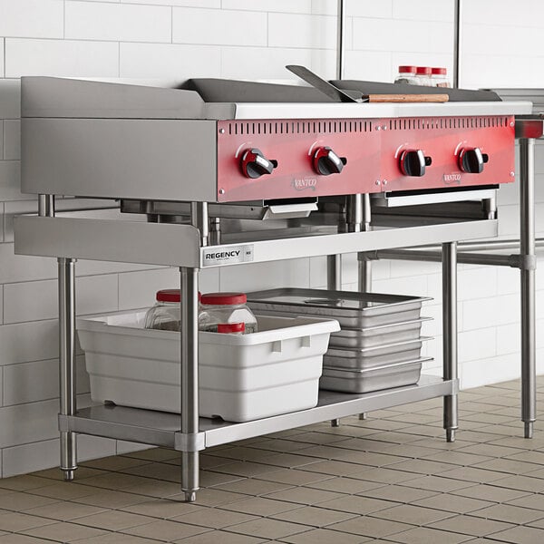 A Regency stainless steel equipment stand with a stainless steel undershelf in a professional kitchen.