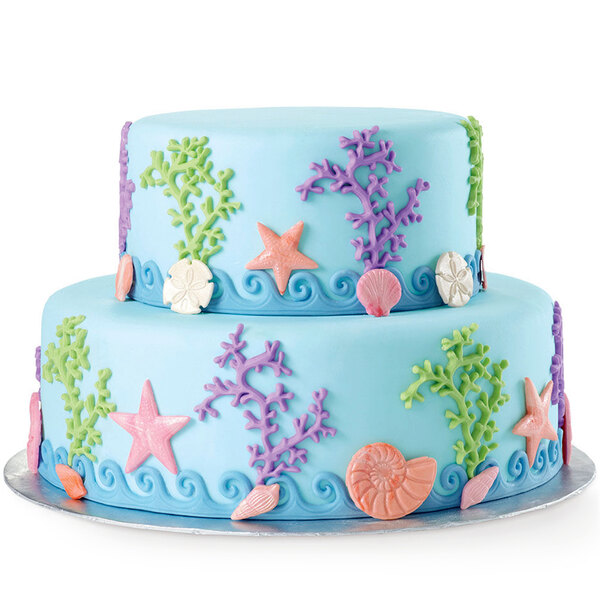A blue cake with sea creatures and starfish decorations made using a Wilton Sea Life silicone mold.