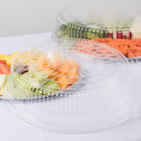 A Durable Packaging clear plastic round high dome lid on a plastic tray with fruit inside.