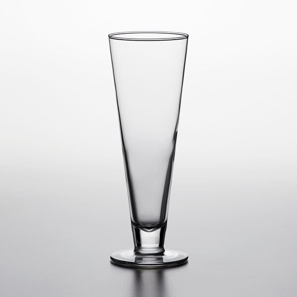 An Arcoroc Classic Footed Pilsner Glass on a table.