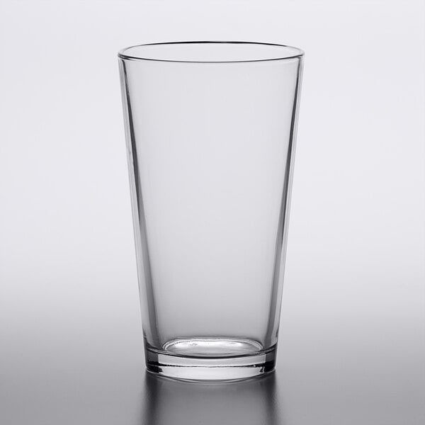 An Arcoroc clear tempered mixing glass with a white background.