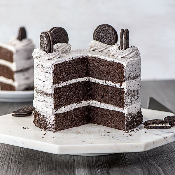 A slice of cake with Rich's Bettercreme Oreo Whipped Icing and Oreo cookie crumbles on top.