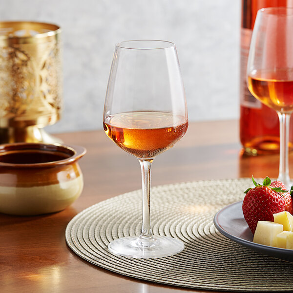 A plate with a glass of Arcoroc wine and strawberries.