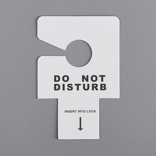 A white Novo Essentials hotel door sign that reads "Do Not Disturb" with a key slot.