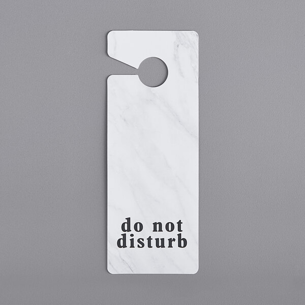 A white Novo Essentials door hanger with black text that says "Do Not Disturb"