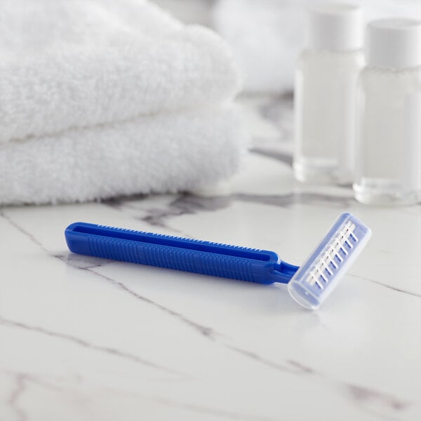 A blue Novo Essentials disposable razor on a marble surface.