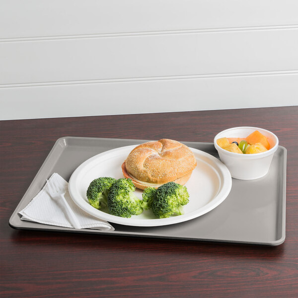 A Cambro dietary tray with a sandwich, fruit, and broccoli on it.