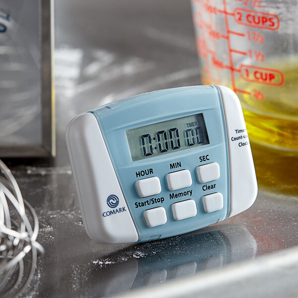A Comark digital kitchen timer on a counter.