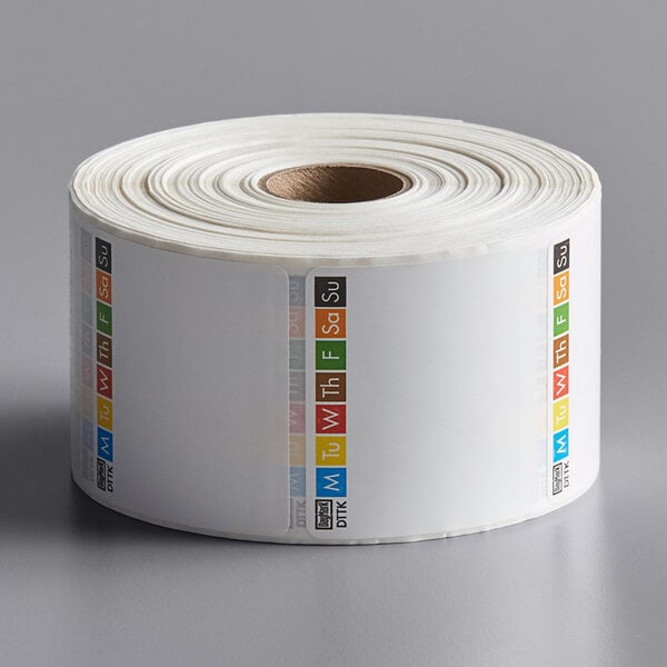 A roll of DayMark white paper labels with colorful borders.