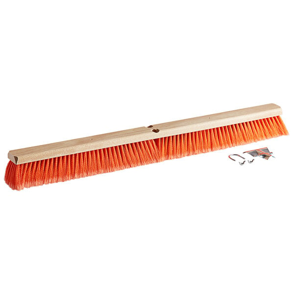 A Carlisle hardwood push broom head with orange flagged polypropylene bristles.