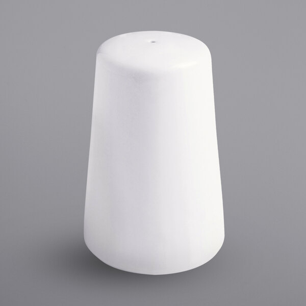 A white porcelain pepper shaker with a round top on a gray surface.