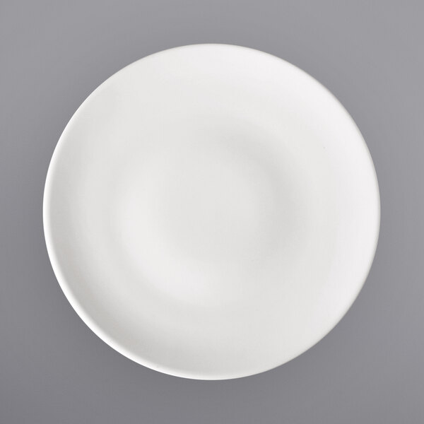 A white porcelain coupe plate with a circular pattern on the rim.