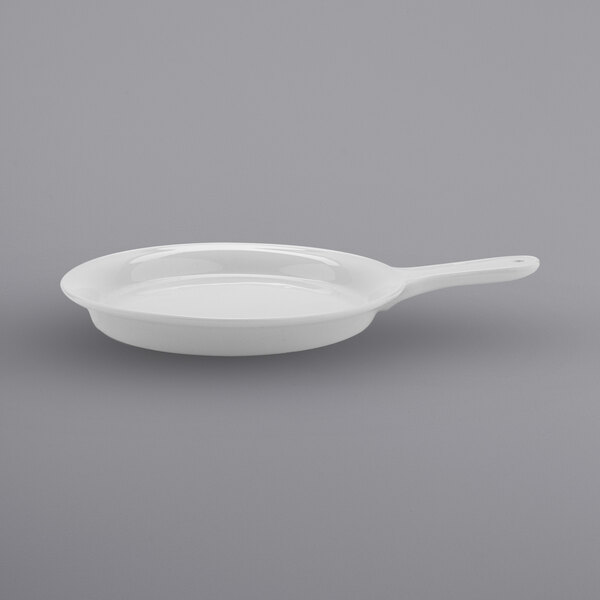 A white porcelain fry pan server with a handle.