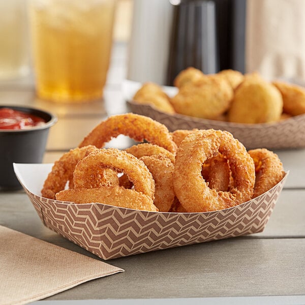 A bowl of fried onion rings in a Carnival King paper food tray on a table.