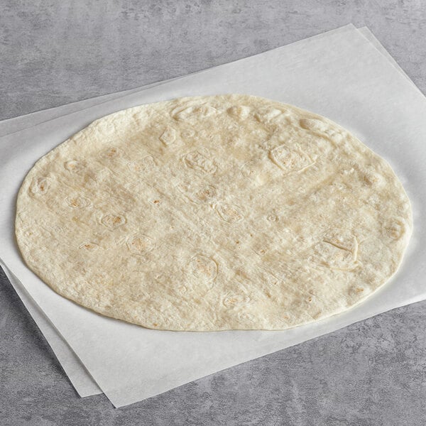 A Father Sam's Bakery flour tortilla on a white surface.