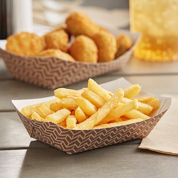 Carnival King paper food trays with french fries and chicken nuggets on a table.
