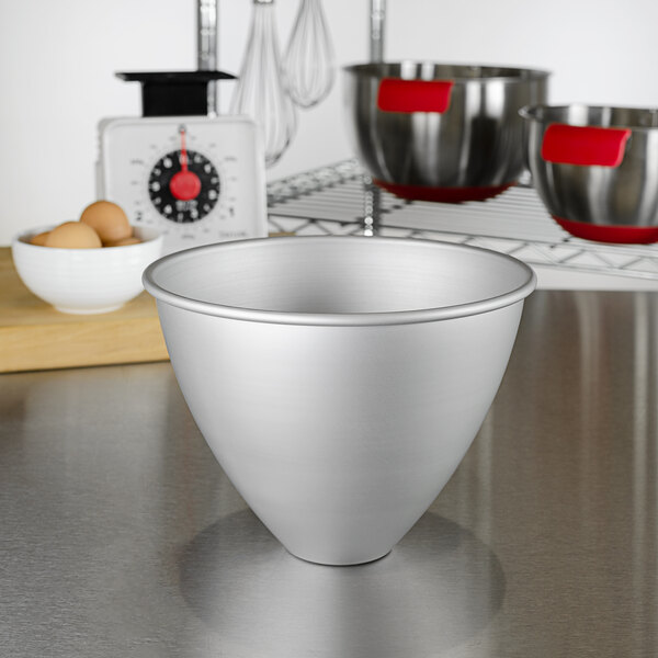 A silver bowl with a cone shape on a counter.