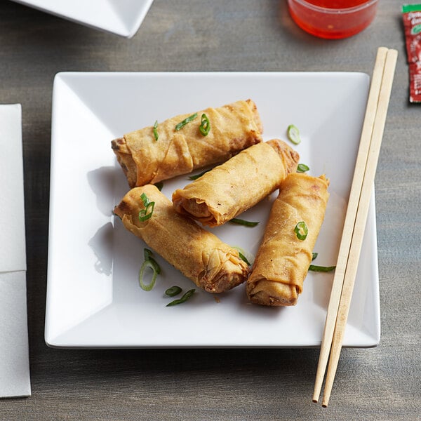 An Acopa Rittenhouse white square melamine plate with fried spring rolls on it.