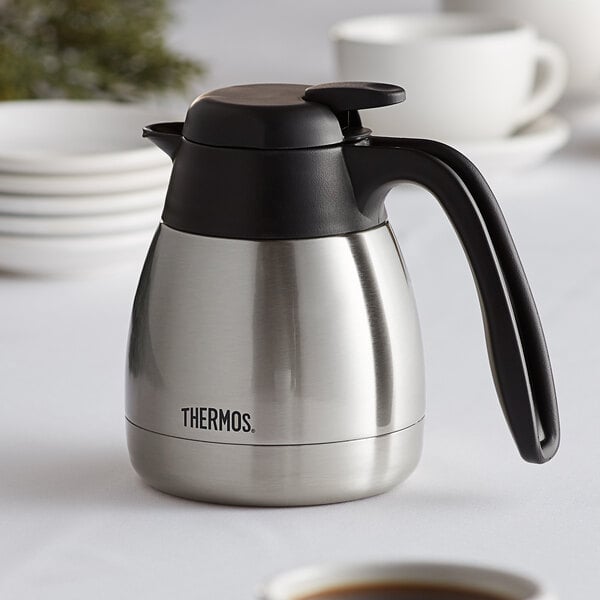 A close-up of a stainless steel Thermos coffee carafe.