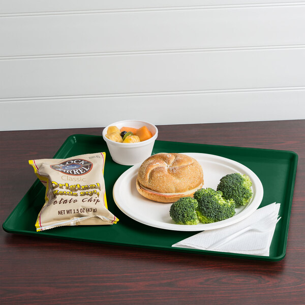 A Cambro Sherwood Green dietary tray with a sandwich, broccoli, and potato chips on it.