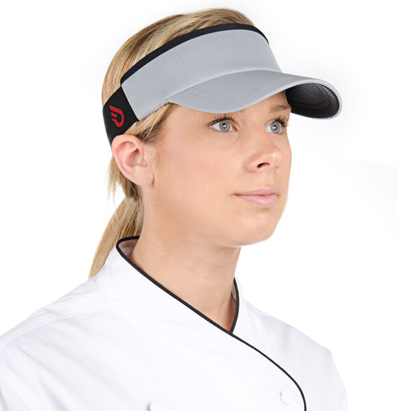 A woman in a chef's uniform wearing a gray Headsweats visor.