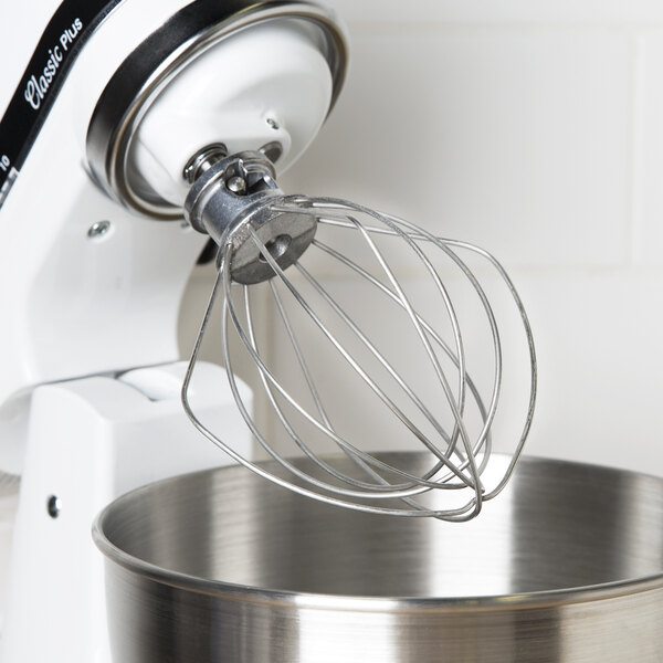A KitchenAid wire whip attached to a mixer.