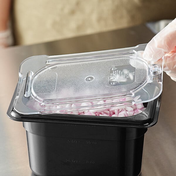 A Vigor 1/9 size clear polycarbonate flat food pan lid on a plastic container with a lid.