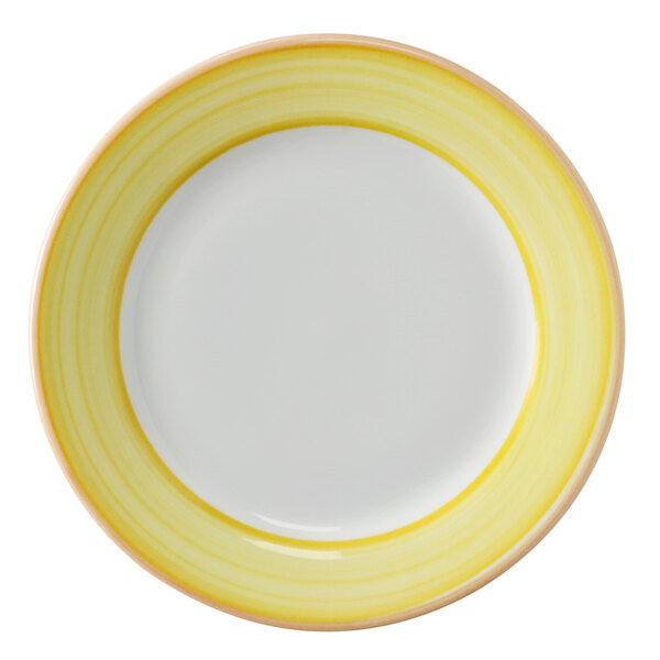 A close-up of a Corona bright white porcelain plate with a yellow and coral rim.