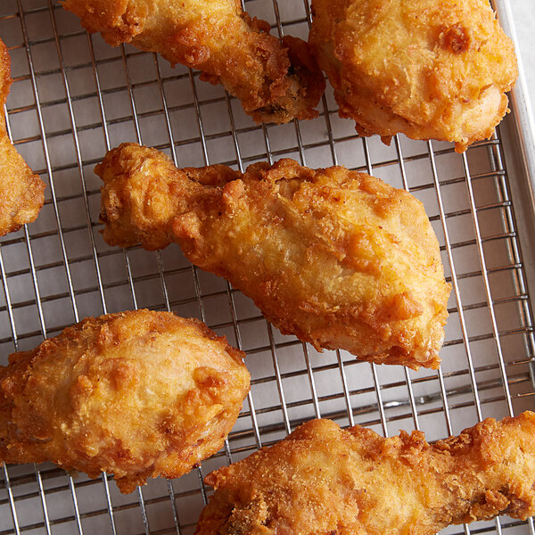 Fried chicken made with J.O. Chicken Fry Batter Blend on a wire rack.