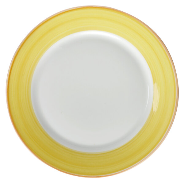 A close-up of a white porcelain plate with a yellow and white rim.