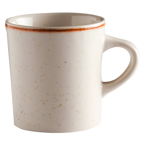 A beige porcelain mug with orange specks on the rim.